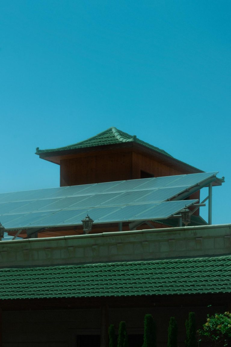 A traditional pagoda with modern solar panels under a clear blue sky.